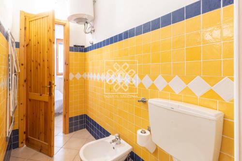 カステルサルドにあるLa Porta sul Mare-Lu Bagnuの黄色のタイル張りの壁、トイレ付きのバスルーム