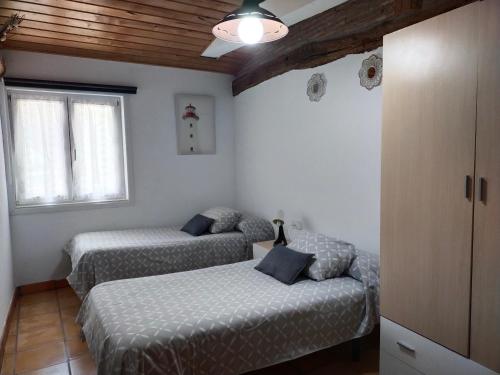 1 dormitorio con 2 camas y ventana en ANTZOMENDI, en Mutriku
