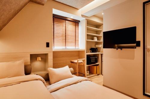 um quarto com 2 camas e uma televisão de ecrã plano em LiveGRACE Mabuji Park Hotel - Vacation STAY 51980v em Tóquio