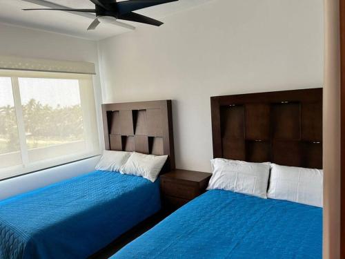 a bedroom with two beds and a window at Vidamar Refugio Costero / Zona Diamante in Acapulco