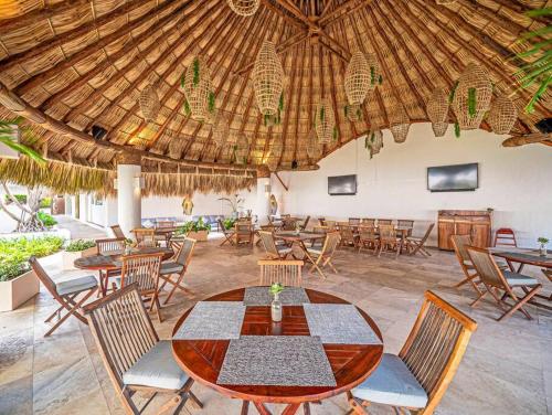 ein Restaurant mit einem Tisch und Stühlen sowie einer Holzdecke in der Unterkunft Vidamar Refugio Costero / Zona Diamante in Acapulco
