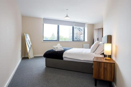 a bedroom with a large bed and a window at Stylish and Bright 2 Bedroom Apartment Manchester in Manchester