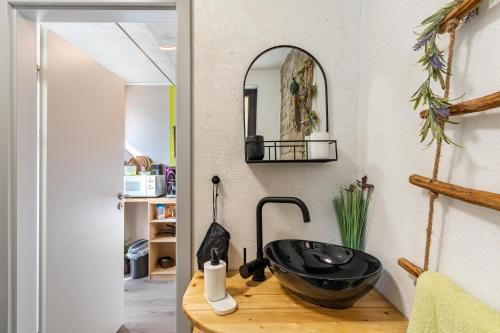 a bathroom with a black sink on a wooden counter at Hobbit Lounge in Eppingen