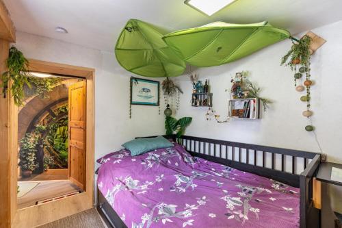 a bedroom with a purple bed and a green umbrella at Hobbit Lounge in Eppingen