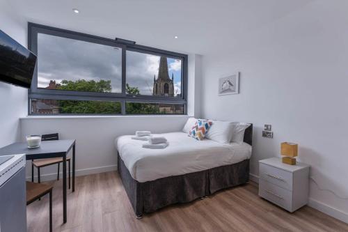 ein Schlafzimmer mit einem Bett und einem großen Fenster in der Unterkunft Charming Studio Apartment in Central Sheffield in Sheffield