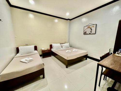een kleine kamer met 2 bedden en een tafel bij AB Star Suites in General Santos