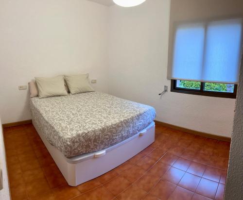 a small bedroom with a bed and a window at AP21-Sa Riera in Begur