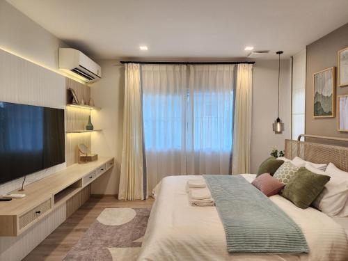 um quarto com uma cama grande e uma televisão de ecrã plano em Narah em Bangna