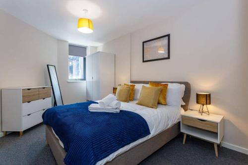 um quarto com uma cama grande e um cobertor azul em Fantastic 1 Bedroom Apartment Manchester em Manchester