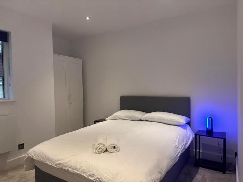 een slaapkamer met een bed met twee slippers erop bij Gallery Apartments in Londen