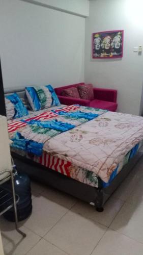 ein Schlafzimmer mit einem Bett und einem Sofa in der Unterkunft Apartemen studio kalibata city square in Jakarta