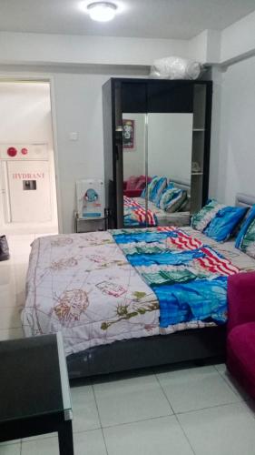 ein Schlafzimmer mit einem Bett und einem großen Spiegel in der Unterkunft Apartemen studio kalibata city square in Jakarta