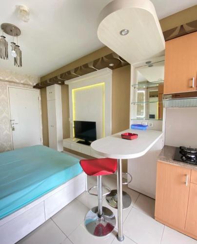 eine kleine Küche mit einem Tisch und einem Bett in der Unterkunft Apartemen studio kalibata city square in Jakarta