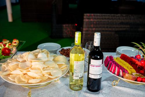 a table with two bottles of wine and plates of food at Dragon Crown Legend Cruise in Ha Long