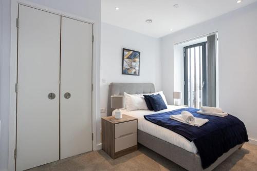een slaapkamer met een kingsize bed en een kast bij Stunning 2 Bedroom Apartment Manchester in Manchester