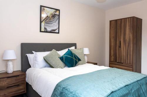 een slaapkamer met een groot bed en een houten kast bij Contemporary 2 Bed Apartment Salford in Manchester