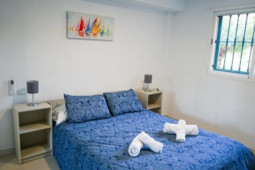 a bedroom with a blue bed with towels on it at Casa Lince: 2/2 in Marbella in Marbella