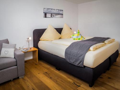 a bed in a room with a chair and a couch at 2 in holiday home Sandra in Hörbranz