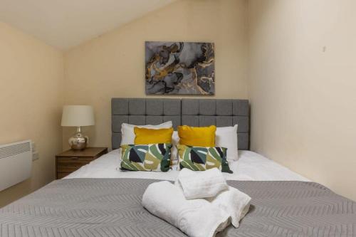 a bedroom with a large bed with yellow pillows at Modern 1 Bed Attic Apartment in Brixton in London