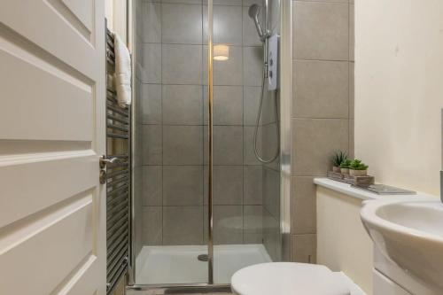 a bathroom with a shower and a toilet and a sink at Modern 1 Bed Attic Apartment in Brixton in London