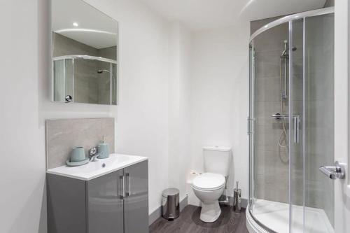 uma casa de banho branca com um WC e um chuveiro em Cosy 1 Bedroom Apartment in Leeds em Leeds