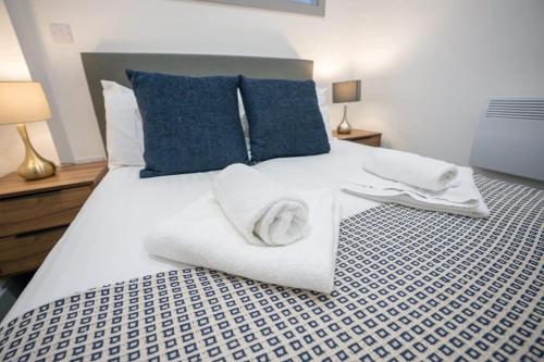 a bedroom with a white bed with towels on it at Cosy 1 Bed Apartment Dudley in Dudley