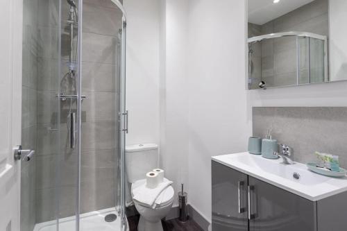 a bathroom with a shower and a toilet and a sink at Cosy 1 Bed Apartment in Leeds in Leeds