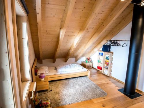 Un dormitorio con una cama en una habitación con techos de madera. en "NisseHus" Comfortable holiday residence, en Gjerstad