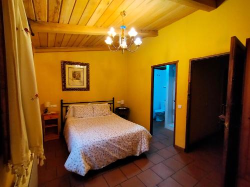 a bedroom with a bed in a room with yellow walls at Casa Rural Garrido in Ademuz