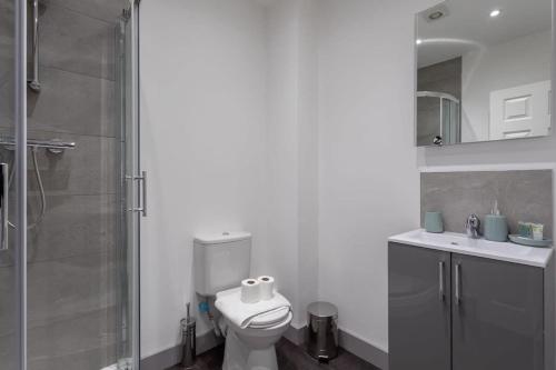 a white bathroom with a toilet and a shower at Charming 1 Bed Apartment in Leeds in Leeds
