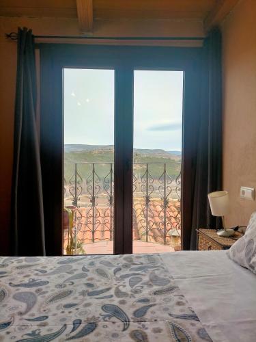 a bedroom with a bed and a view of a balcony at Casa Rural Garrido in Ademuz