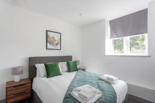 a bedroom with a bed with green and white pillows at Modern 1 Bedroom Apartment Leeds in Leeds
