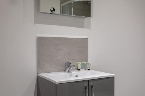 a bathroom with a sink and a mirror at Modern 1 Bedroom Apartment Leeds in Leeds