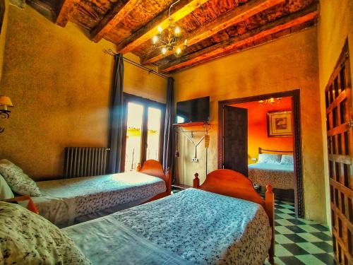 a bedroom with two beds and a tv in it at Casa Rural Garrido in Ademuz