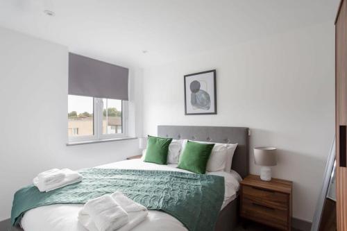 Schlafzimmer mit einem Bett mit grünen und weißen Kissen in der Unterkunft Cosy & Modern 1 Bed Apartment Leeds in Leeds