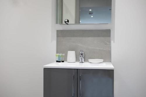 a bathroom with a sink and a mirror at Lovely 1 Bedroom Apartment Leeds in Leeds