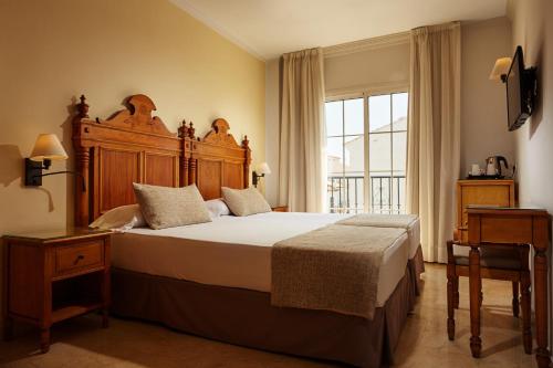 a bedroom with a large bed and a large window at Hotel Villa Flamenca in Nerja