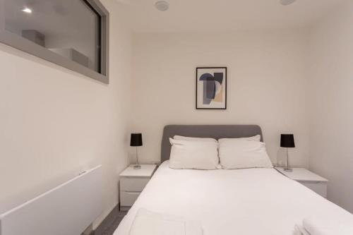 a white bedroom with a bed and two night stands at Fantastic 1 Bedroom Apartment Leeds in Leeds