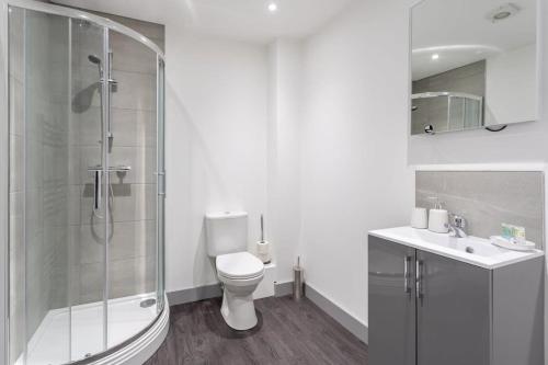 a bathroom with a shower and a toilet and a sink at Contemporary 1 Bedroom Apartment Leeds in Leeds