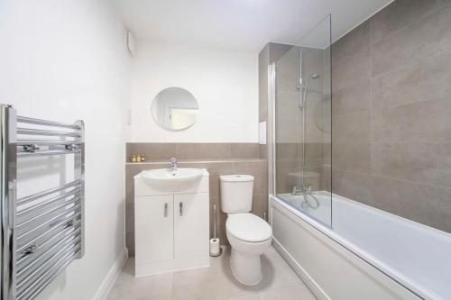 a bathroom with a toilet and a sink and a bath tub at Lovely 1 Bedroom Apartment in Ashford in Ashford