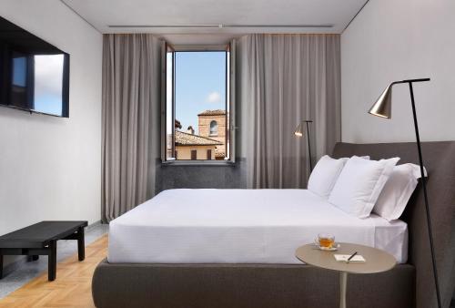 a hotel room with a bed and a window at The Bank Hotel - Locanda della Posta Dependance in Perugia
