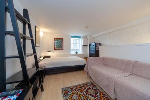 a bedroom with a bed and a couch at Charming 1 Bedroom Apartment in old School House in London