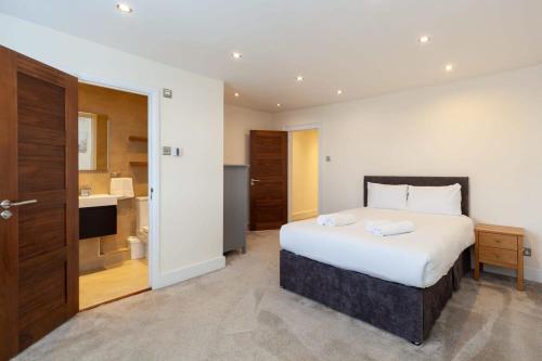a bedroom with a large bed and a bathroom at Spacious 2 Bedroom Maisonette in Stratford in London