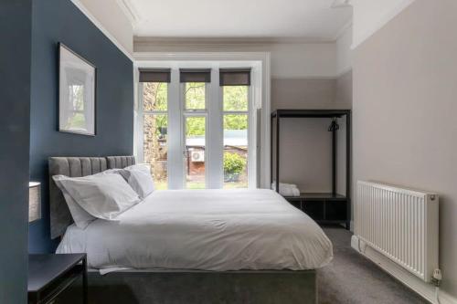 a bedroom with a large bed and a window at Beautiful Apartment in a stone built Victorian residence in Leeds