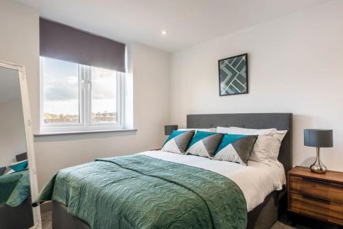 a bedroom with a large bed and two windows at Cosy 1 Bed Flat in Leeds in Leeds
