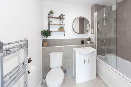 a white bathroom with a toilet and a sink at Contemporary 1 Bedroom Apartment in Ashford in Ashford