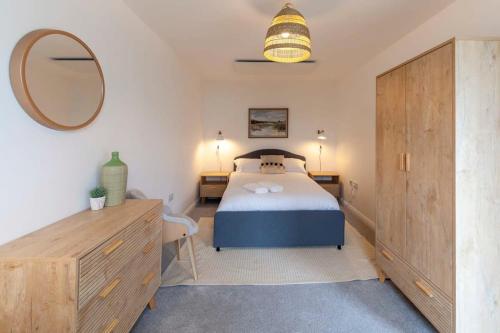 a bedroom with a bed and a mirror and a dresser at Contemporary 1 Bedroom Apartment in Ashford in Ashford