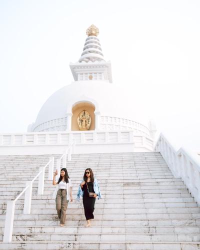 two women walking up the stairs of a temple at Hokke Lumbini in Lumbini
