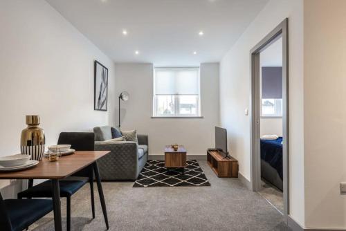 a living room with a table and a couch at Lovely Compact 1 Bed Apartment in Leeds in Leeds