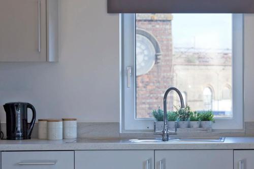 a kitchen counter with a sink and a window at Modern 1 Bedroom Apartment in Ashford in Ashford